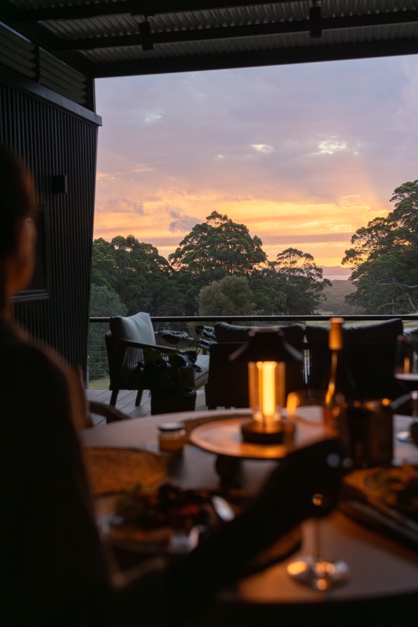 Table setting with lantern at two-bedroom cabin in Denmark WA with sunset in the background